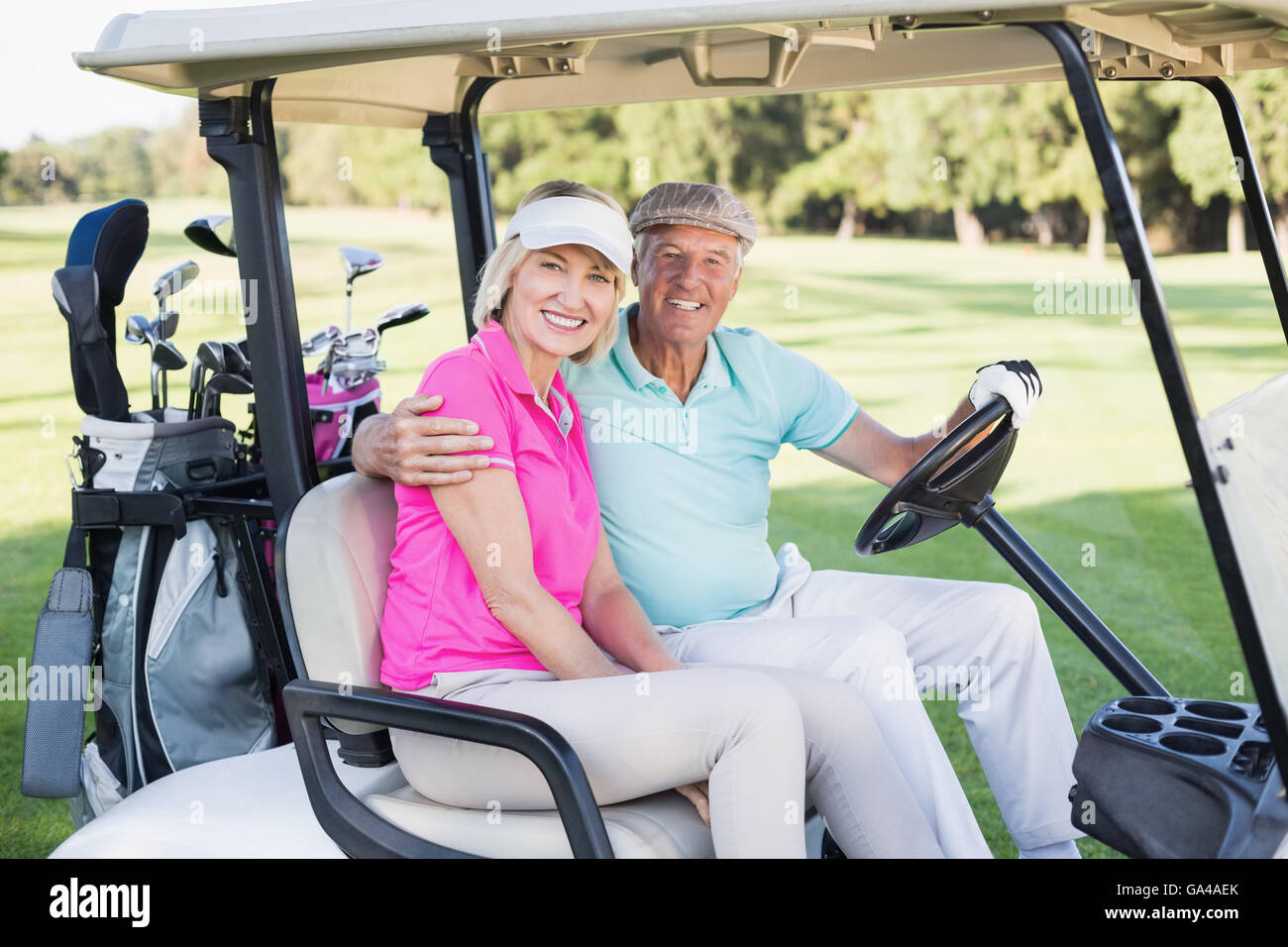 Young couple sitting in voiturette de golf Banque D'Images