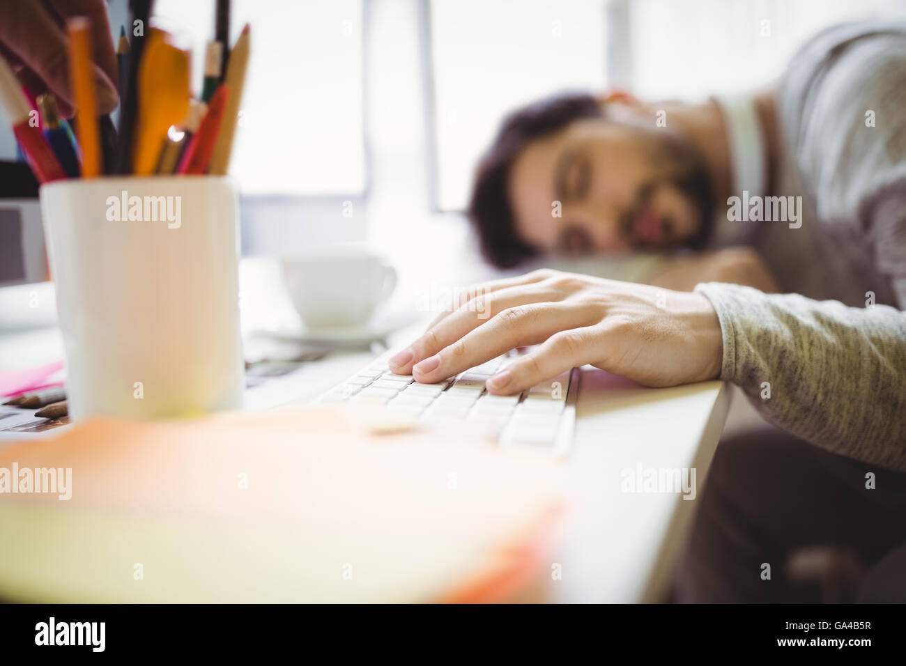 Businessman taking nap in office Banque D'Images