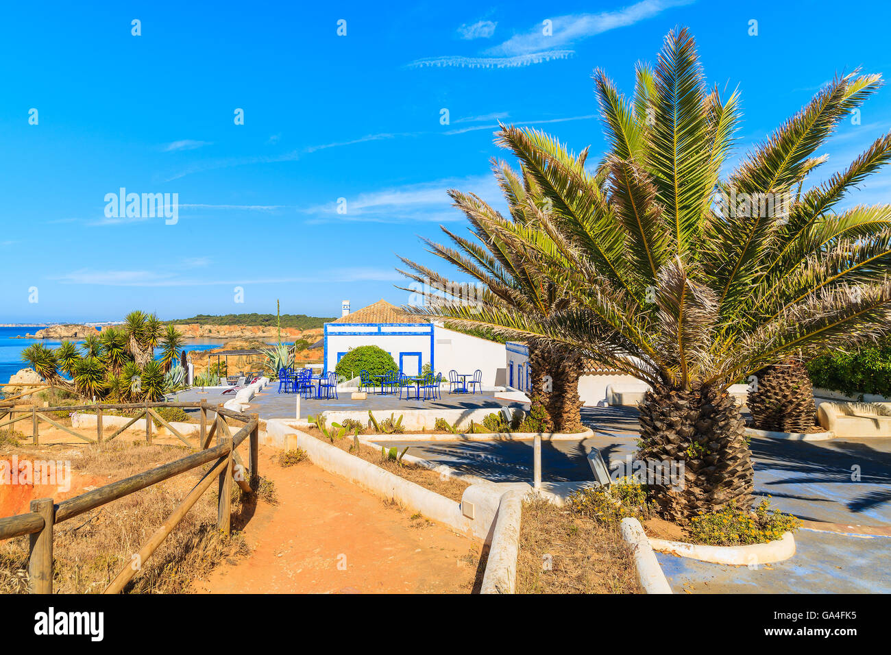 Les palmiers et les maisons sur chemin côtier le long de la plage de Praia da Rocha, Algarve, Portugal Banque D'Images