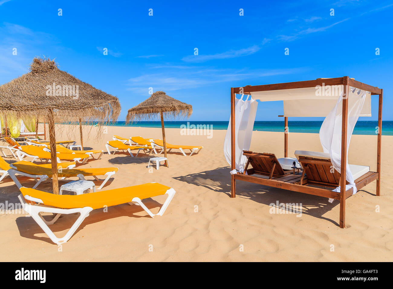 Des chaises longues sur la plage de sable dans la ville balnéaire de Salema, Alrgarve région, Portugal Banque D'Images