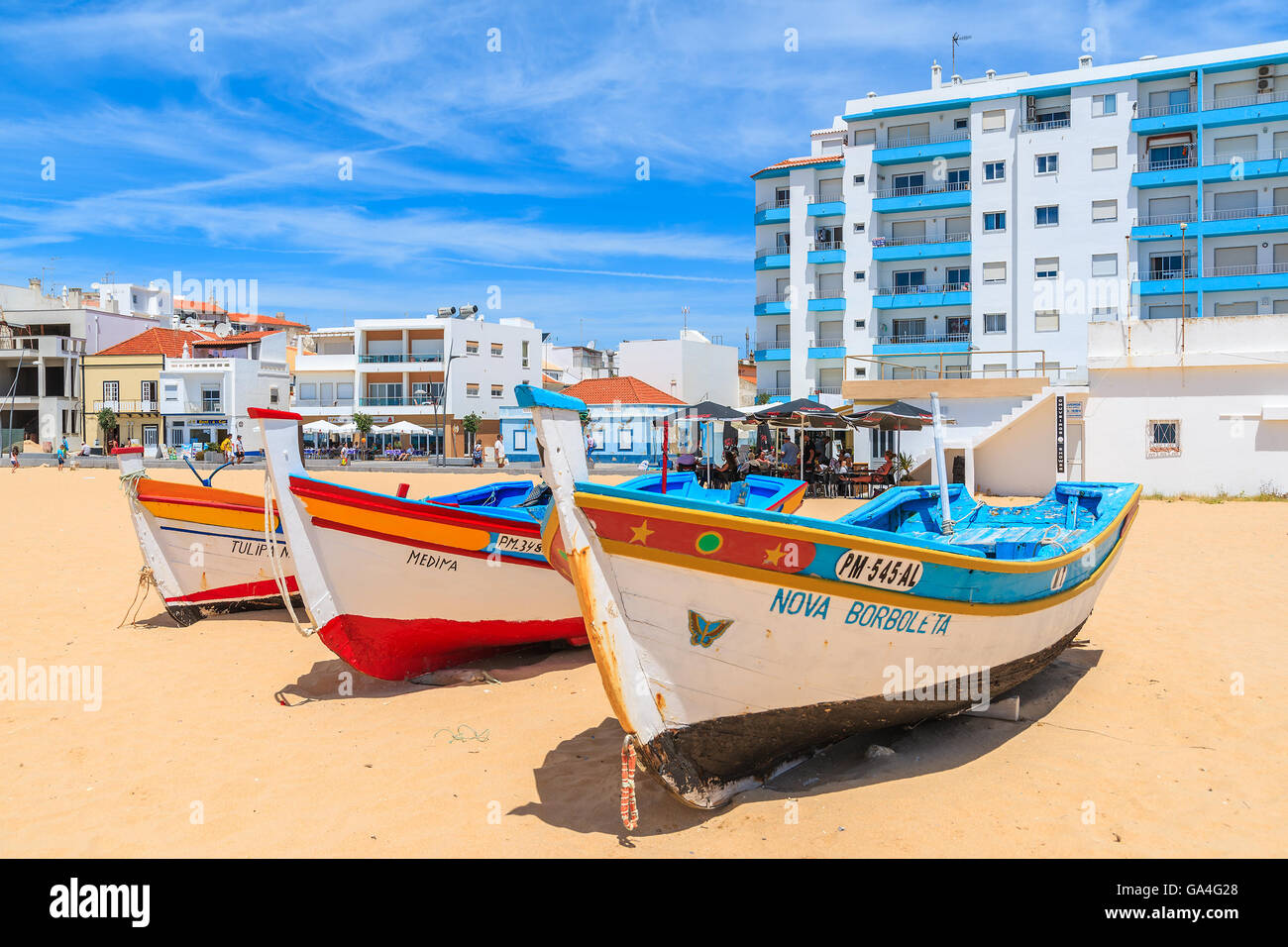 ARMACAO DE PERA, PORTUGAL - 17 MAI 2015 : typique des bateaux de pêche sur la plage à Armacao de Pera ville côtière avec un immeuble en arrière-plan. Région de l'Algarve est une destination de vacances populaire. Banque D'Images