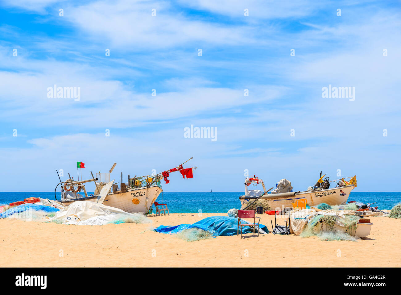 ARMACAO DE PERA, PORTUGAL - 17 MAI 2015 : deux bateaux de pêche colorés typiques sur la plage de sable contre la mer bleue à Armacao de Pera ville balnéaire, le Portugal. Banque D'Images