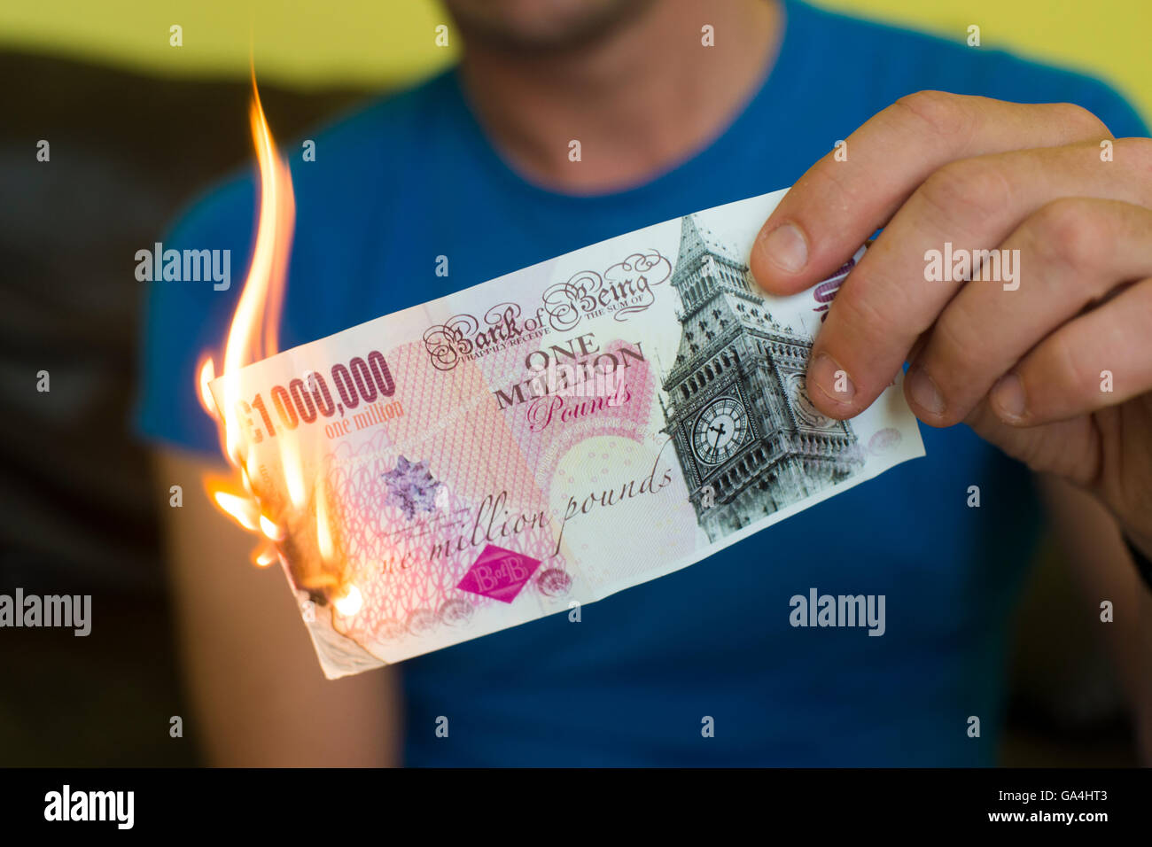 Un homme en train de mettre le feu à un million pound note, symbole de l'effondrement de l'économie britannique post brexit ; de l'argent en fumée Banque D'Images