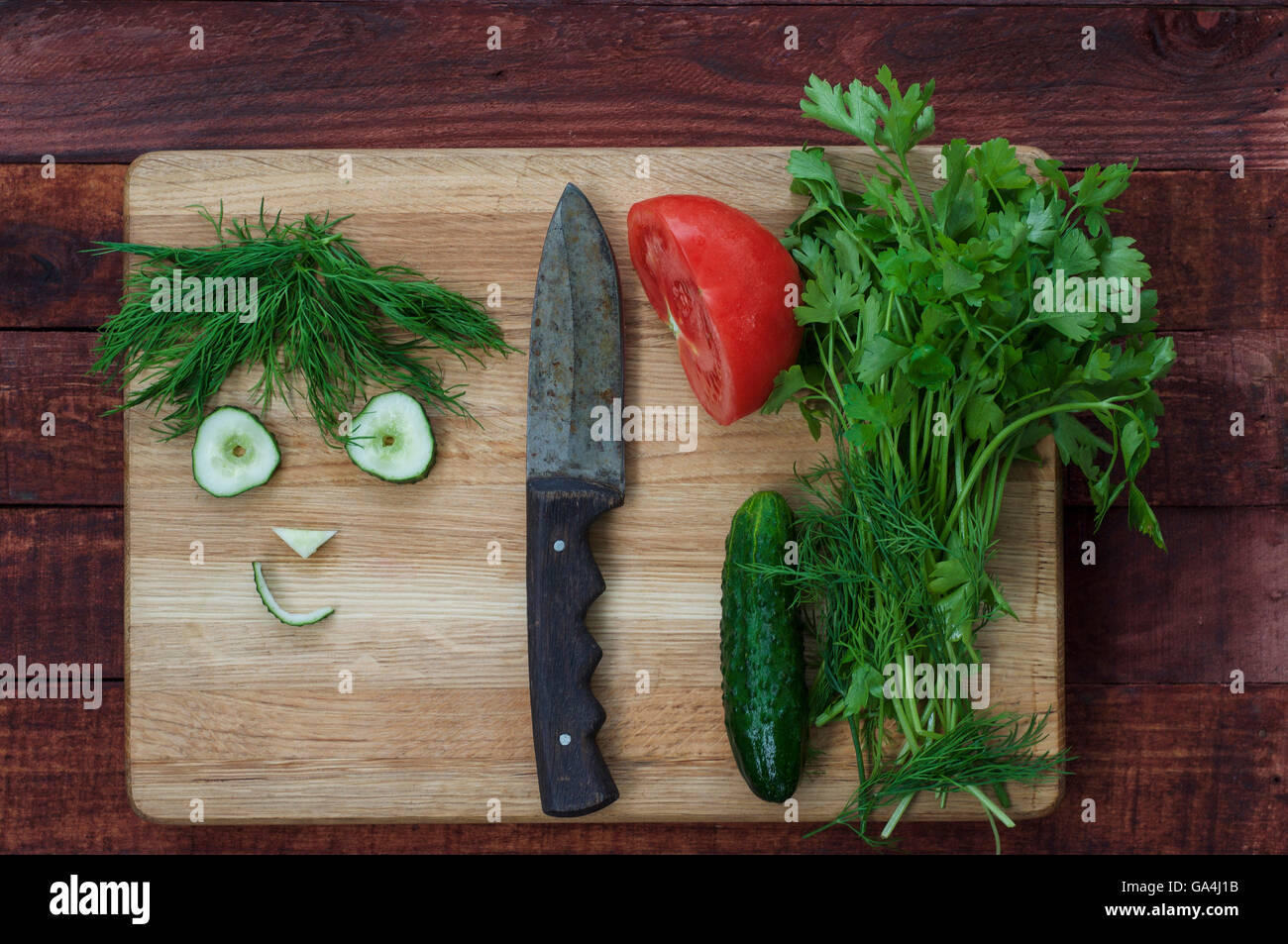 Légumes pour salade saine, tranchées, drôle de visage concombre et aneth Banque D'Images