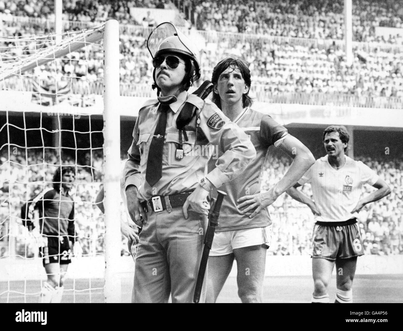 Paul Mariner en Angleterre reçoit l'aide d'un policier espagnol essayer de récupérer le ballon de la foule Banque D'Images