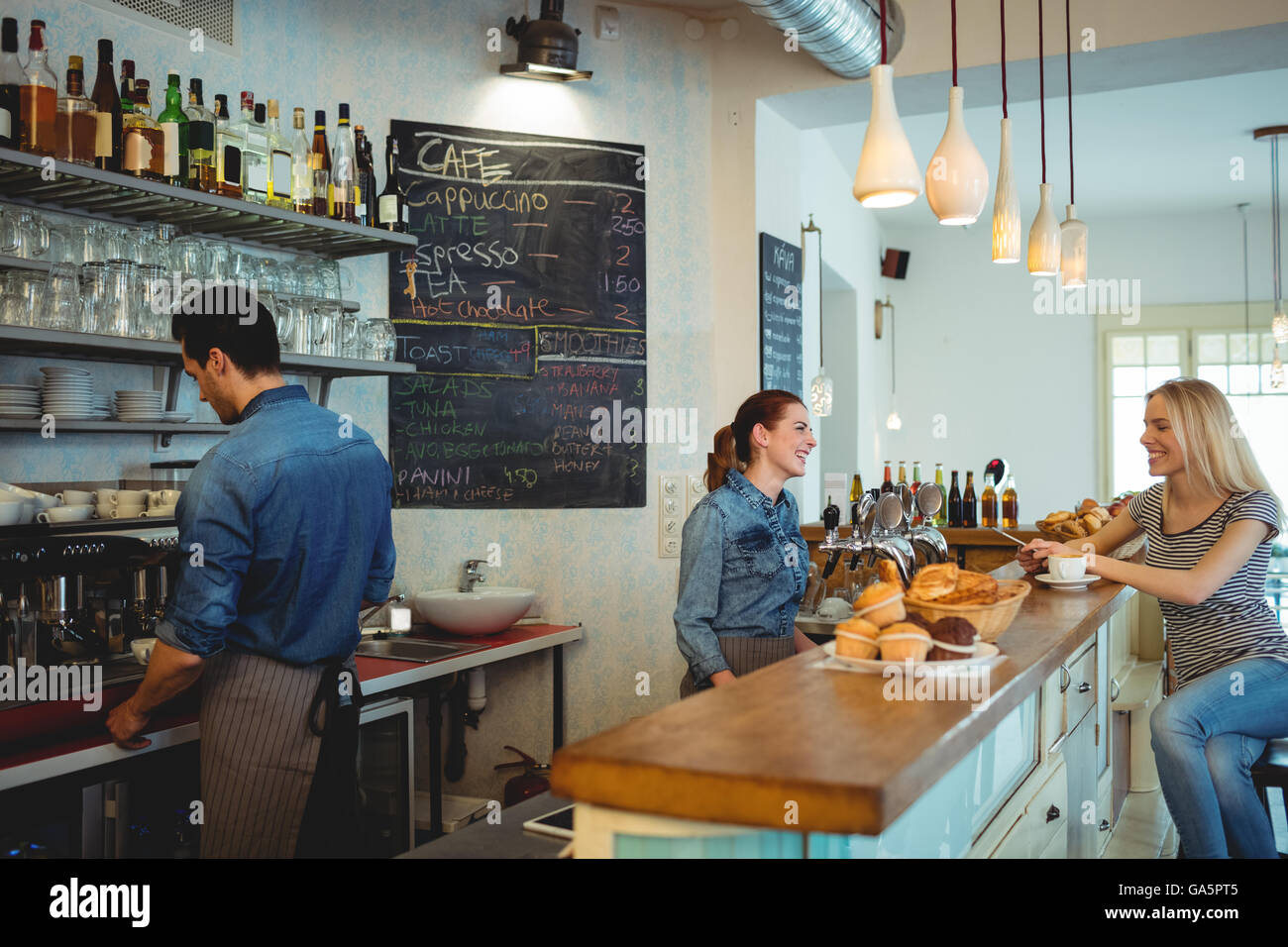 Barista heureux communication avec client à cafétéria Banque D'Images