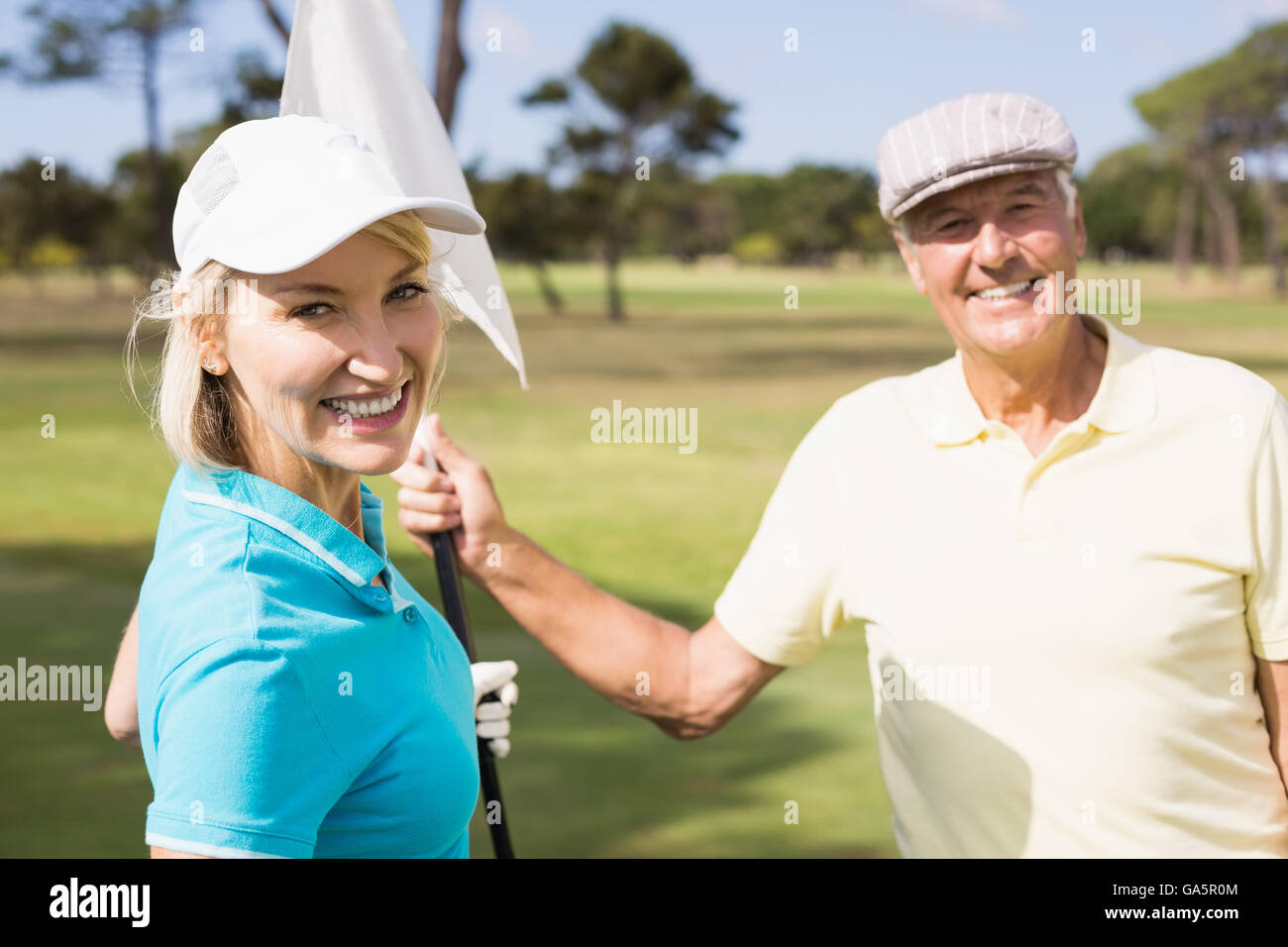 Golfeur joyeux couple holding drapeau blanc Banque D'Images