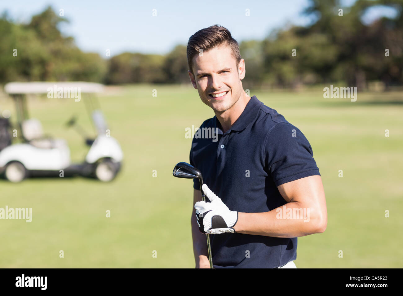 Portrait of young man holding golf club Banque D'Images