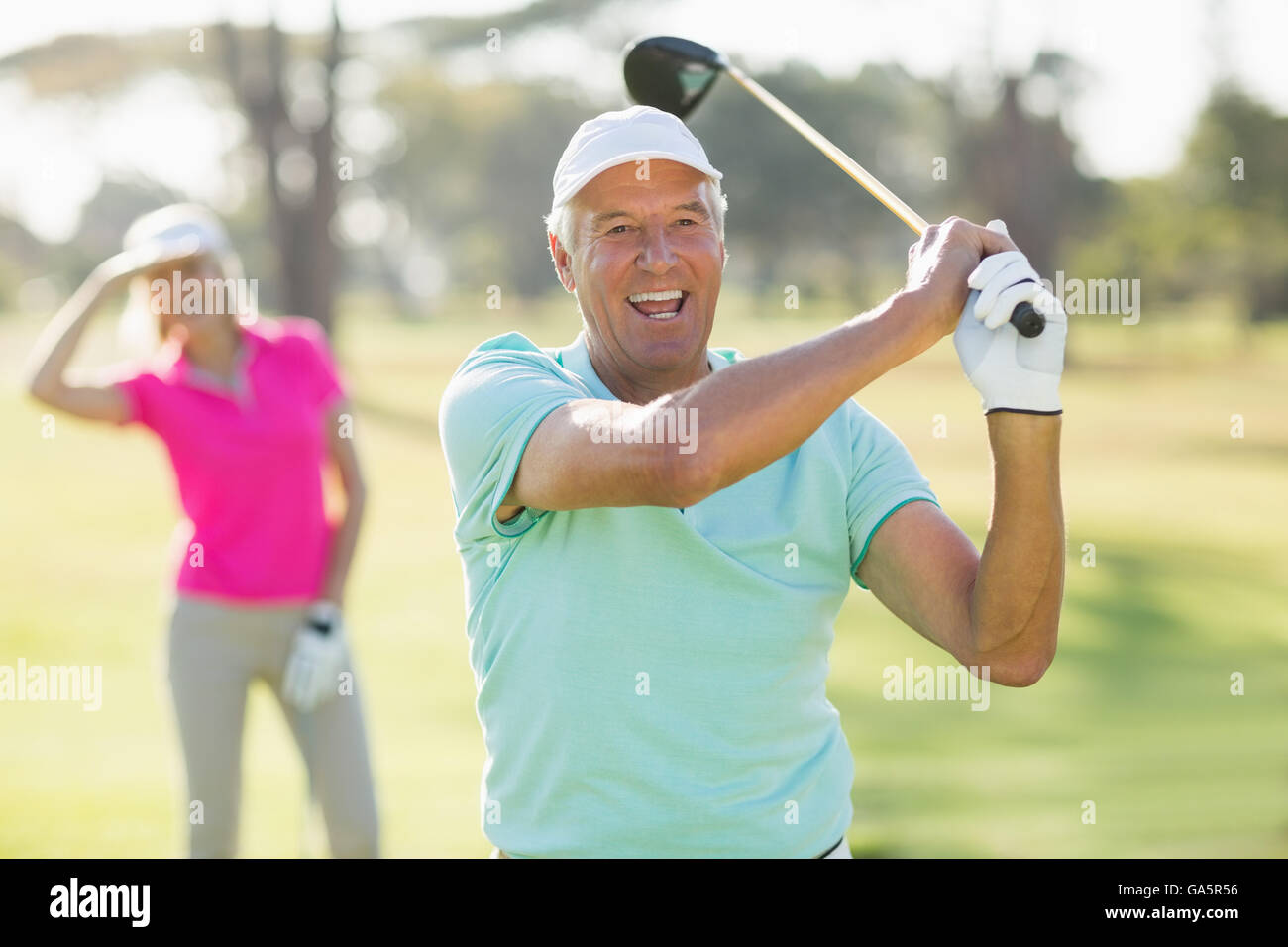 Portrait of cheerful mature golfer holding golf club Banque D'Images