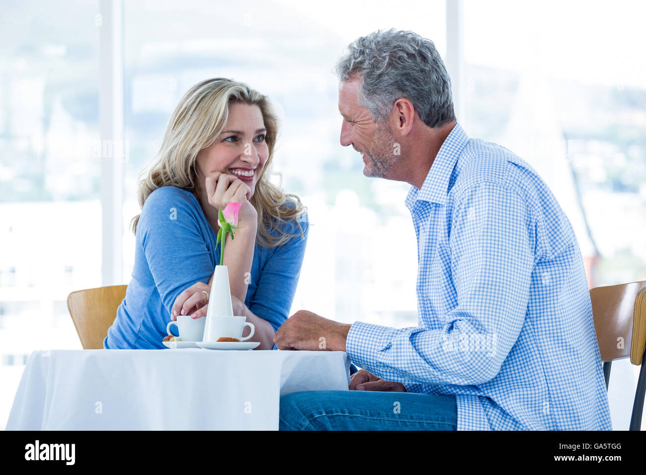 Romantic couple sitting in restaurant Banque D'Images
