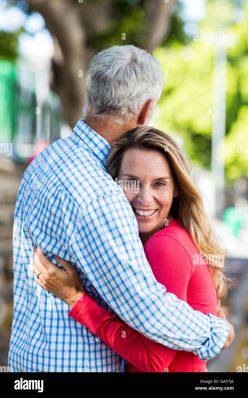 Young woman hugging man par tree Banque D'Images