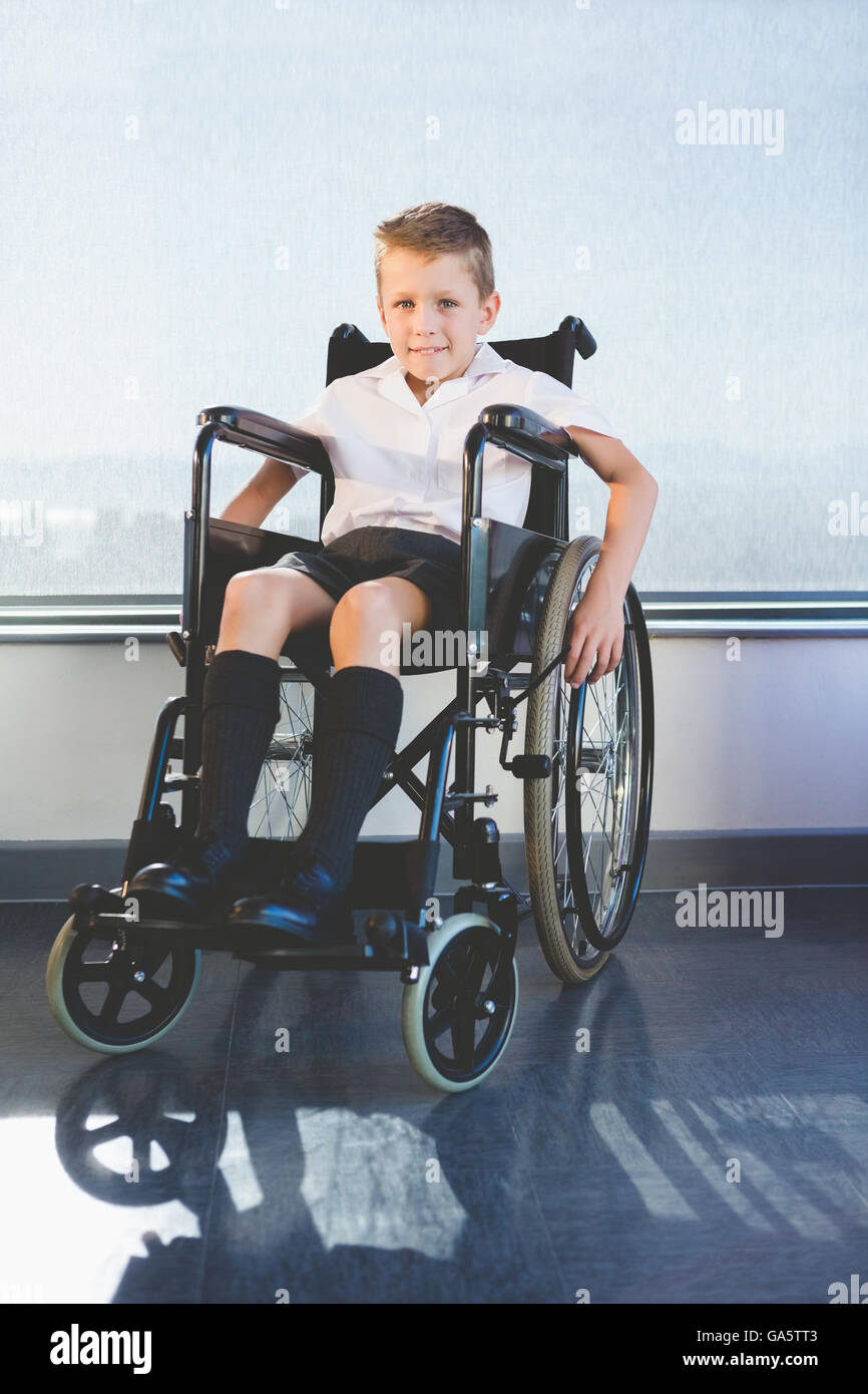 Portrait de schoolkid assis sur fauteuil roulant Banque D'Images