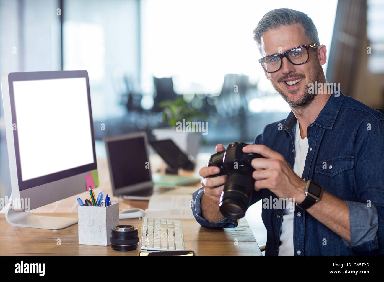 Portrait of smiling man holding camera Banque D'Images