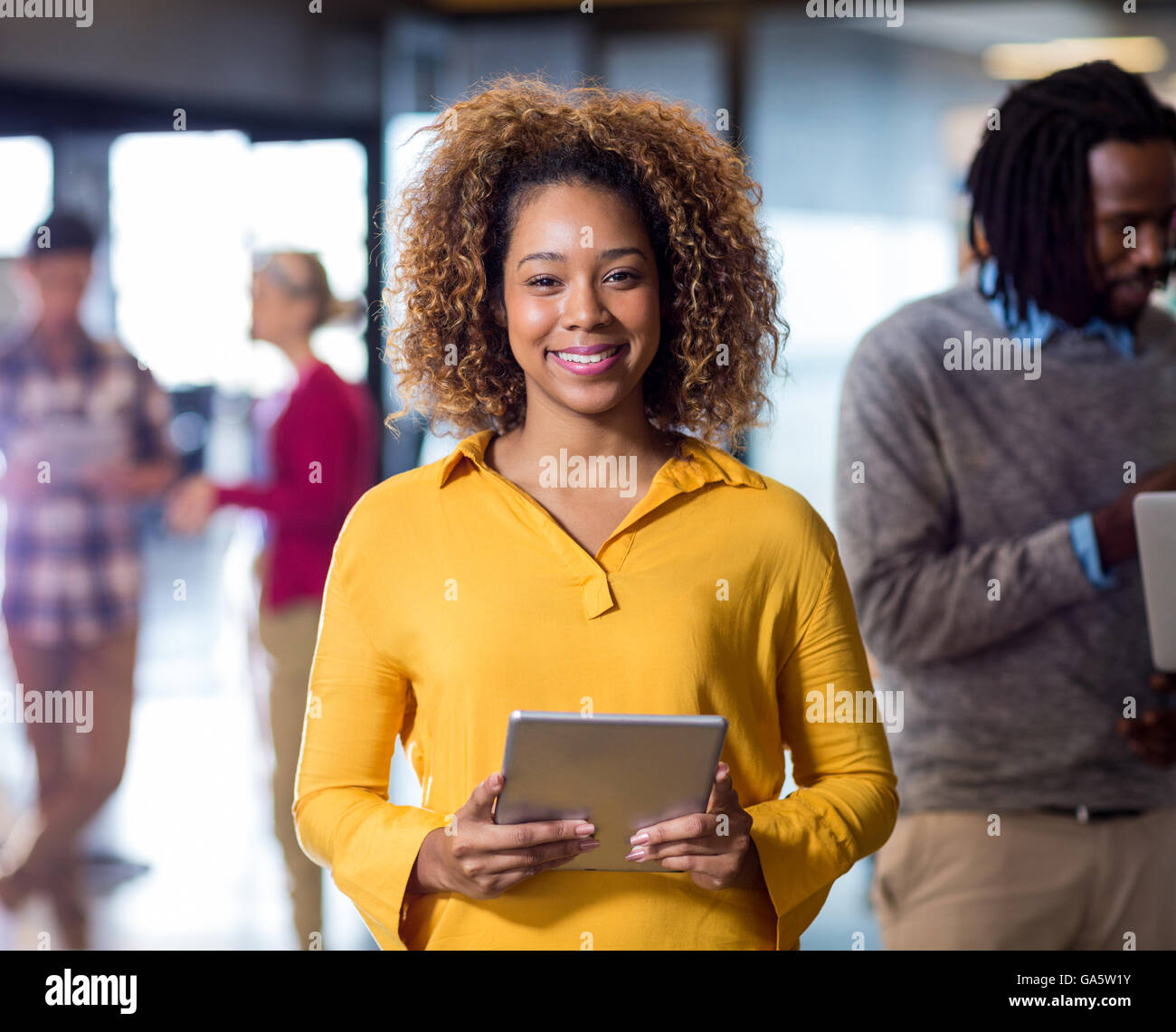 Portrait of woman holding digital tablet in office Banque D'Images