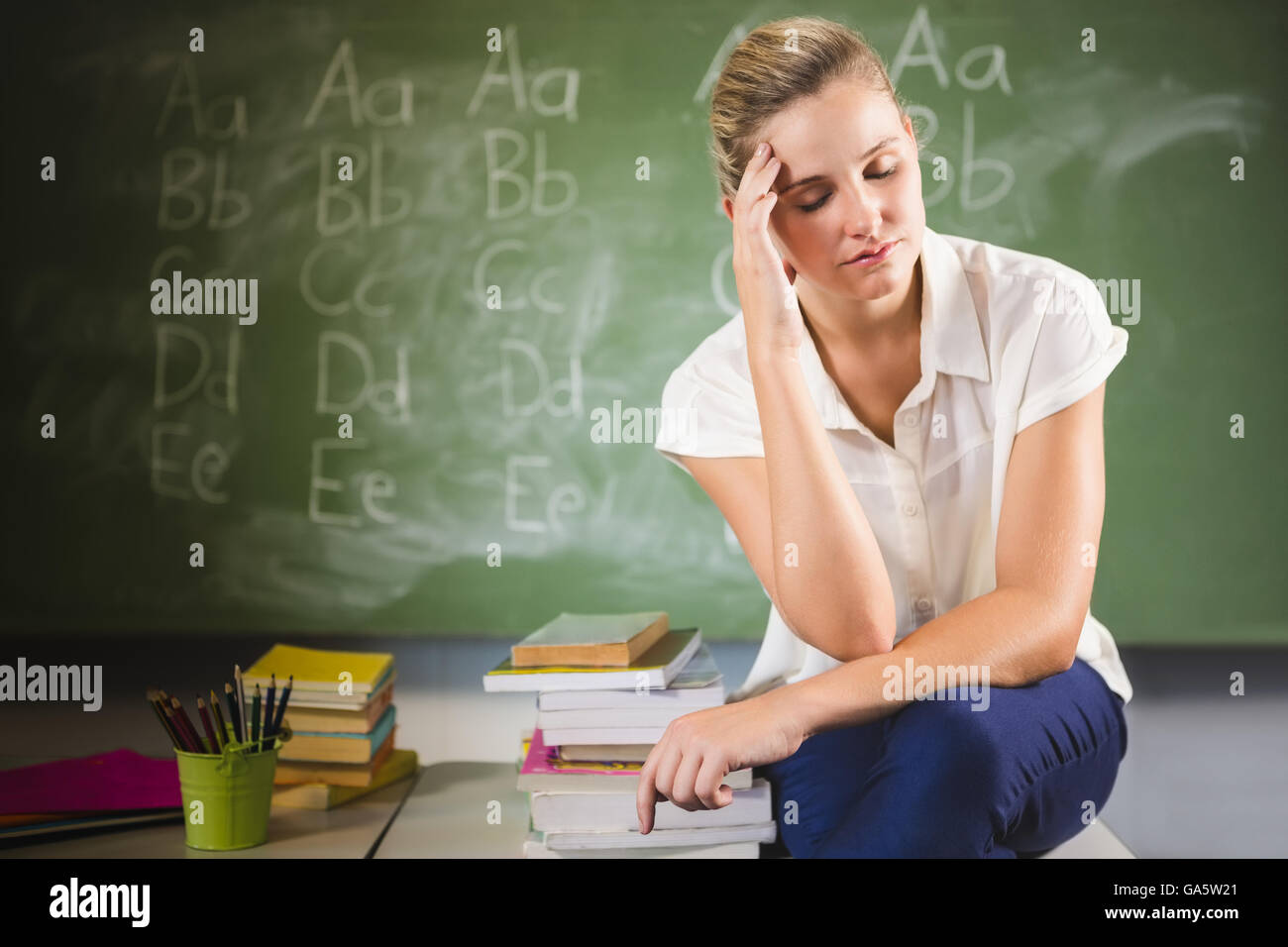 L'enseignant se raidit sitting in classroom Banque D'Images