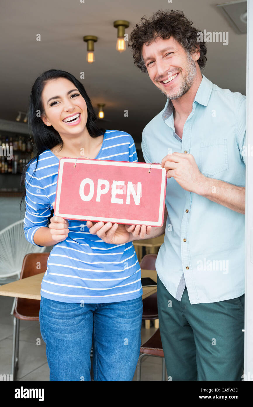 Couple holding ouvrir pancarte Banque D'Images