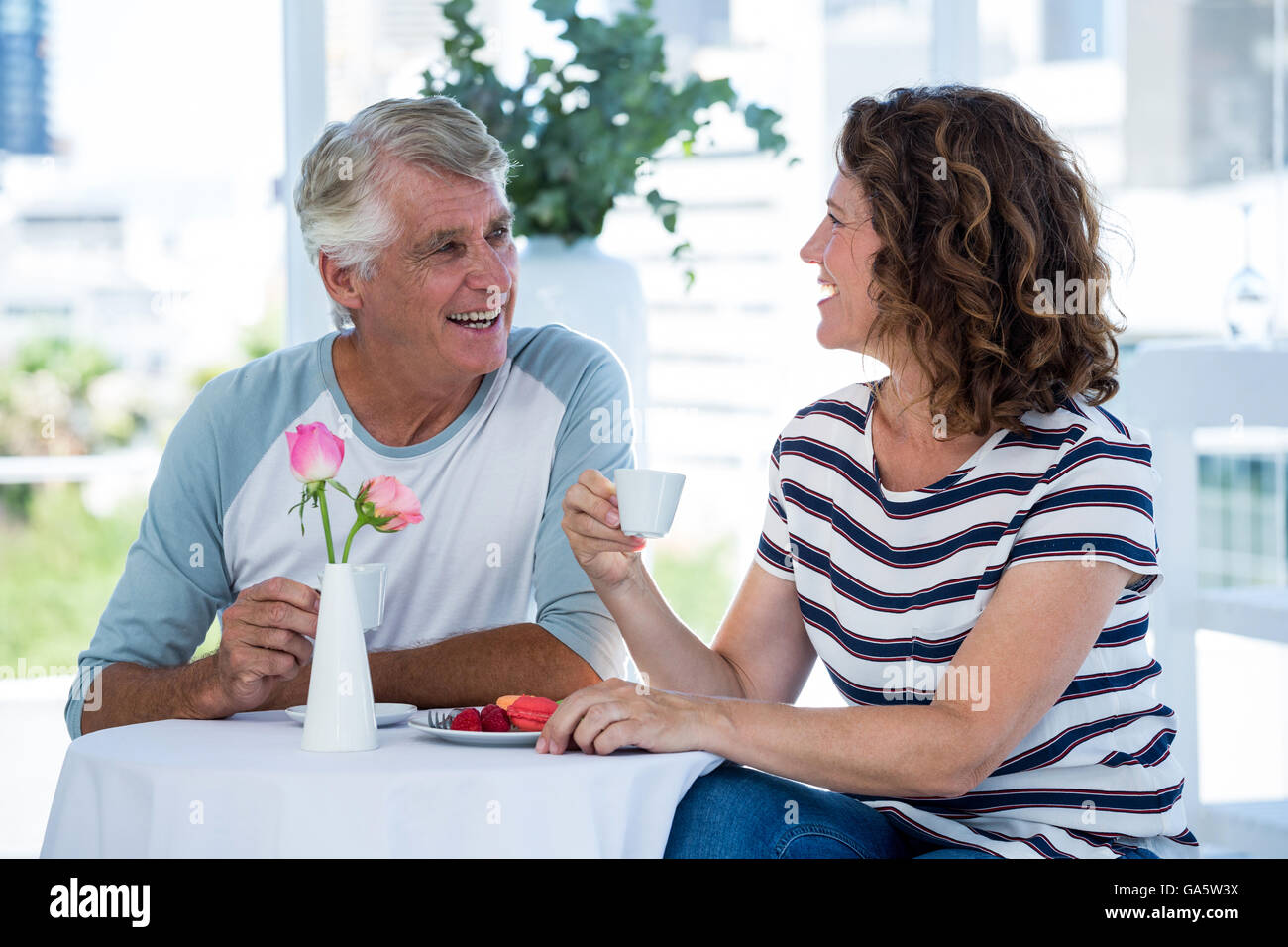 Smiling couple talking while sitting at restaurant Banque D'Images