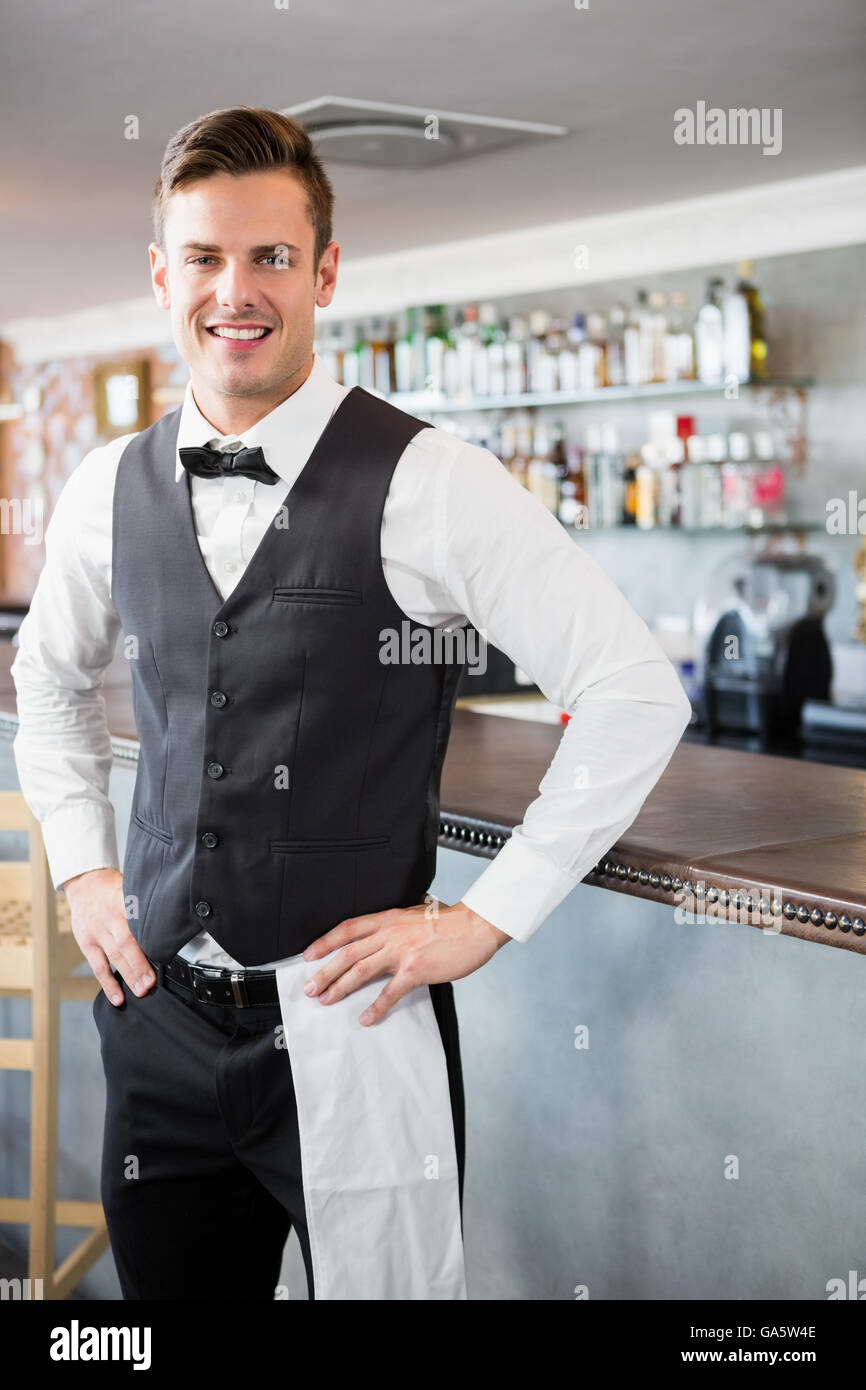 Portrait of waiter standing at bar counter Banque D'Images