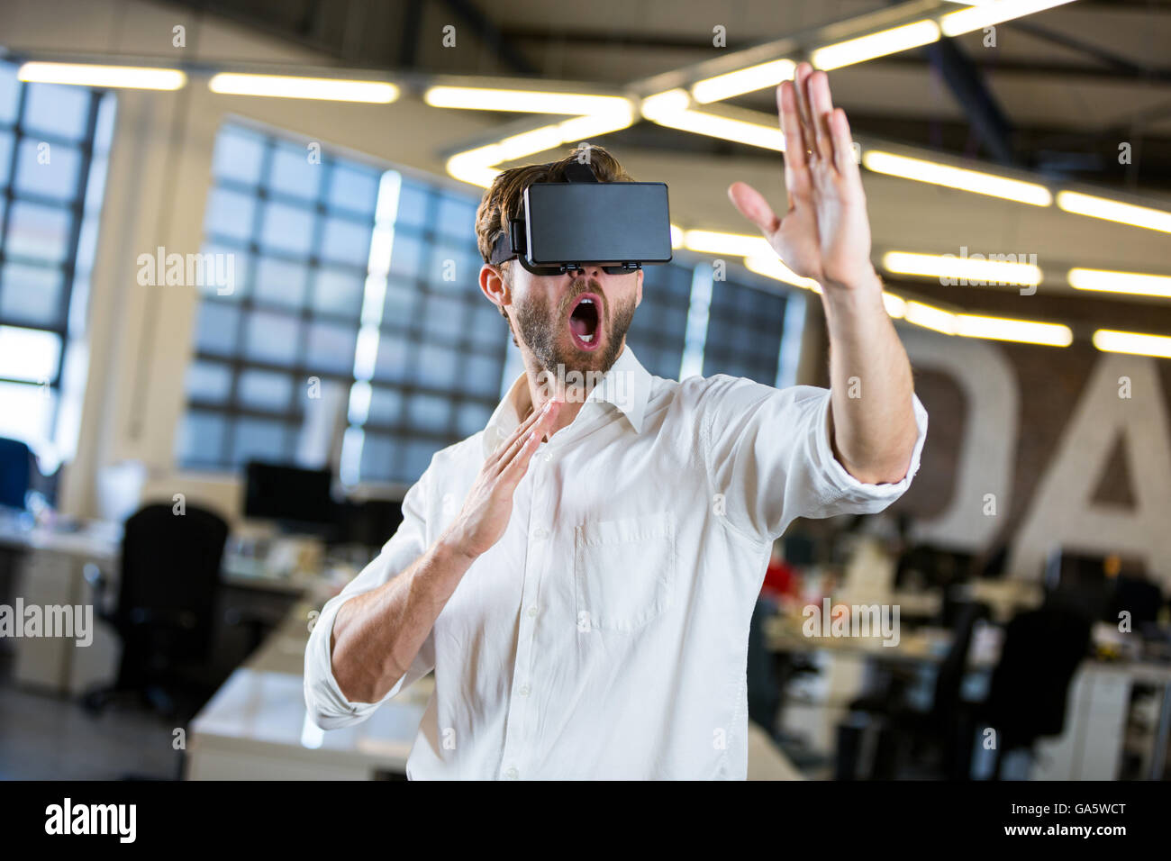 Jeune homme d'affaires à l'aide d'un simulateur de réalité virtuelle Banque D'Images