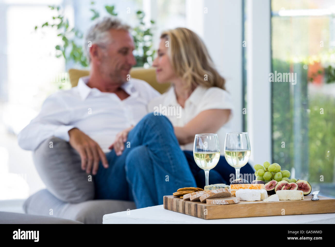Vin blanc et de la nourriture sur table avec couple romantique Banque D'Images