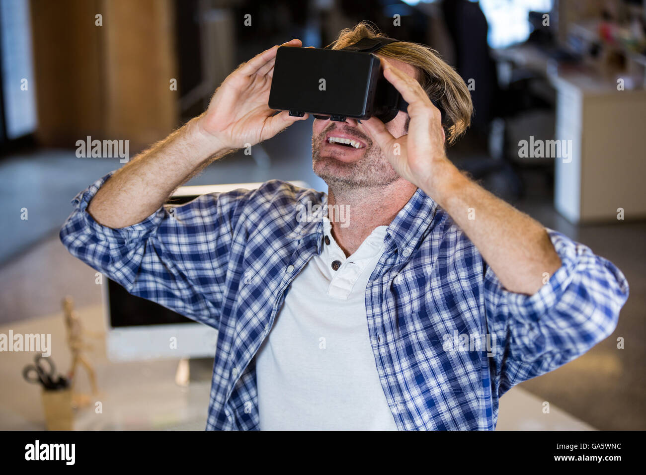 Smiling businessman en utilisant le simulateur de réalité virtuelle Banque D'Images
