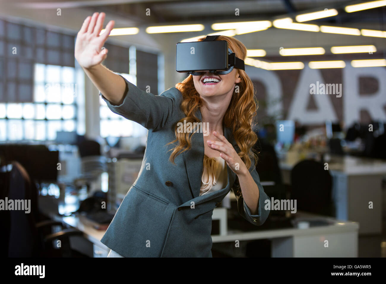 Cheerful woman en utilisant le simulateur de réalité virtuelle Banque D'Images