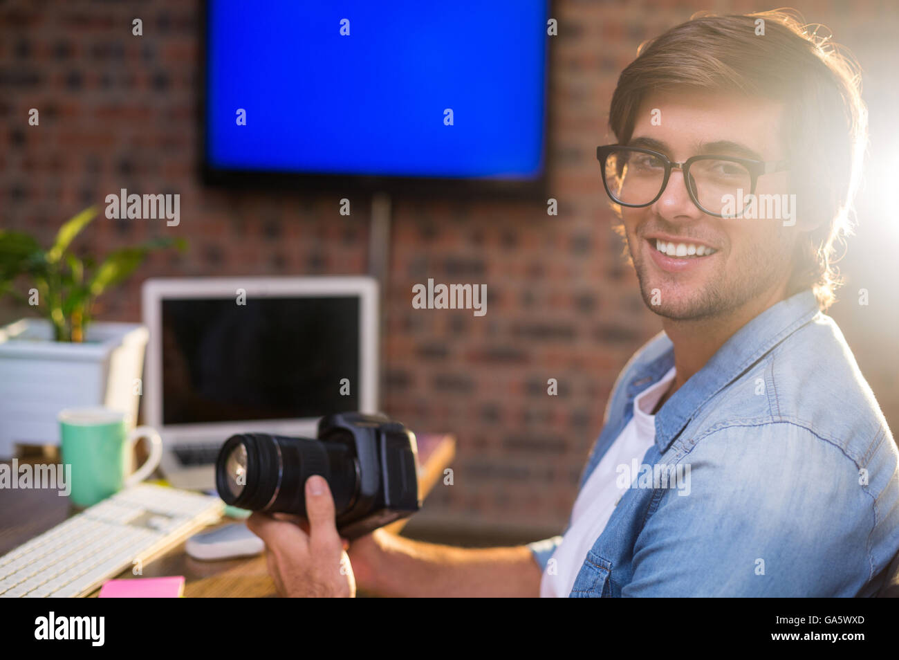 Portrait of smiling man holding camera Banque D'Images
