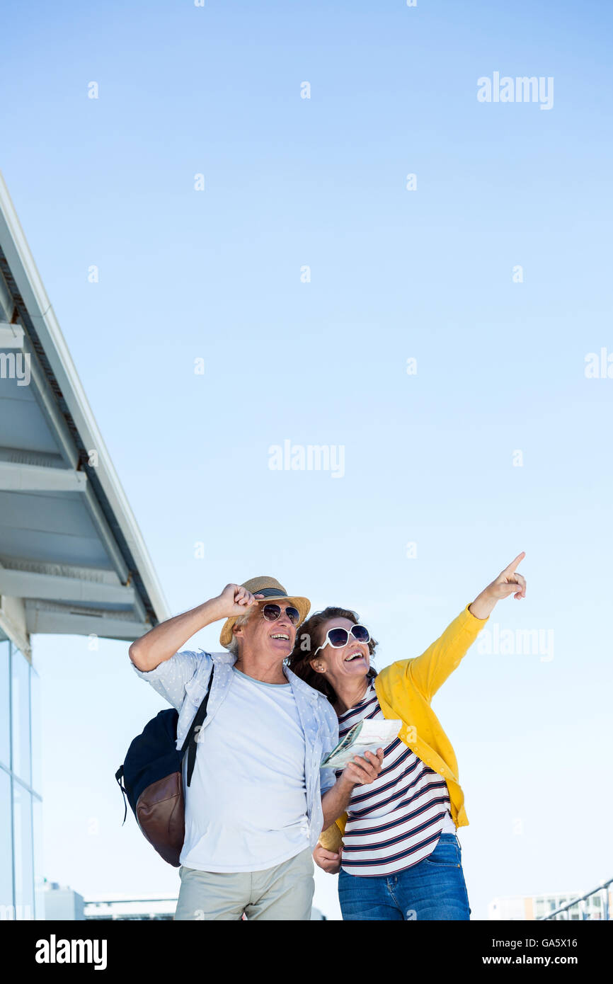 Femme avec homme pointant contre ciel clair Banque D'Images