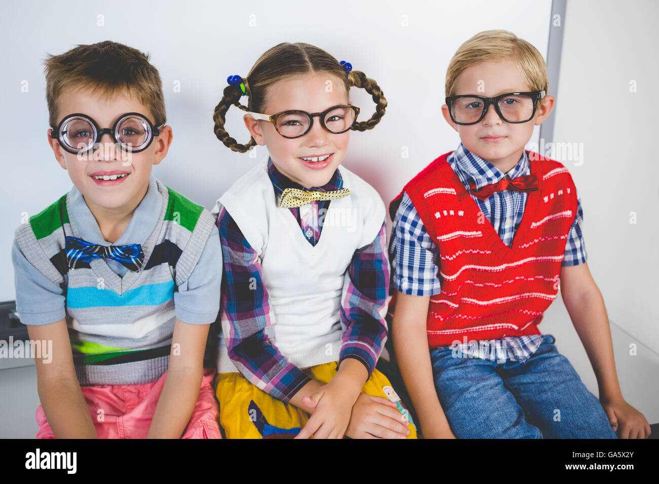 Schoolkids Smiling sitting in classroom Banque D'Images