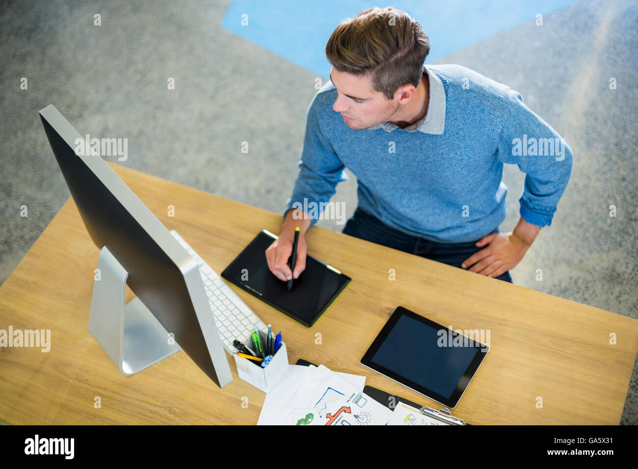 Businessman working on graphics tablet in office Banque D'Images