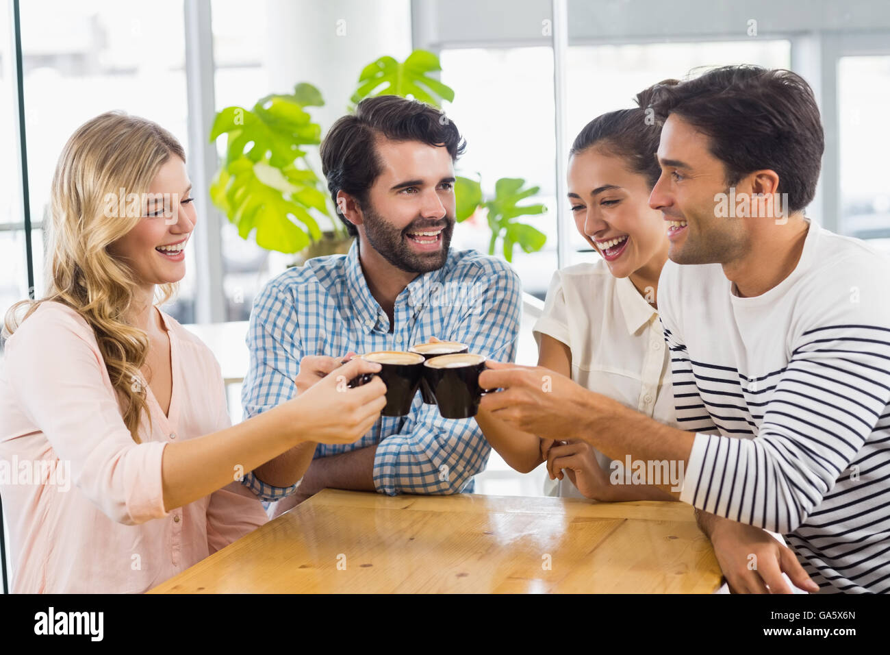 Groupe d'happy friends toasting tasse de café Banque D'Images