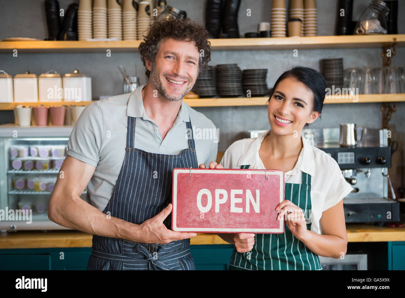 Portrait de serveur et serveuse holding open pancarte Banque D'Images