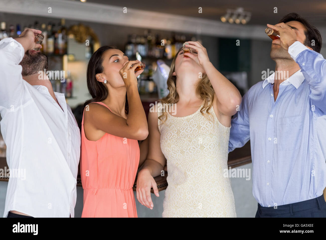 Groupe d'amis ayant la tequila shot Banque D'Images