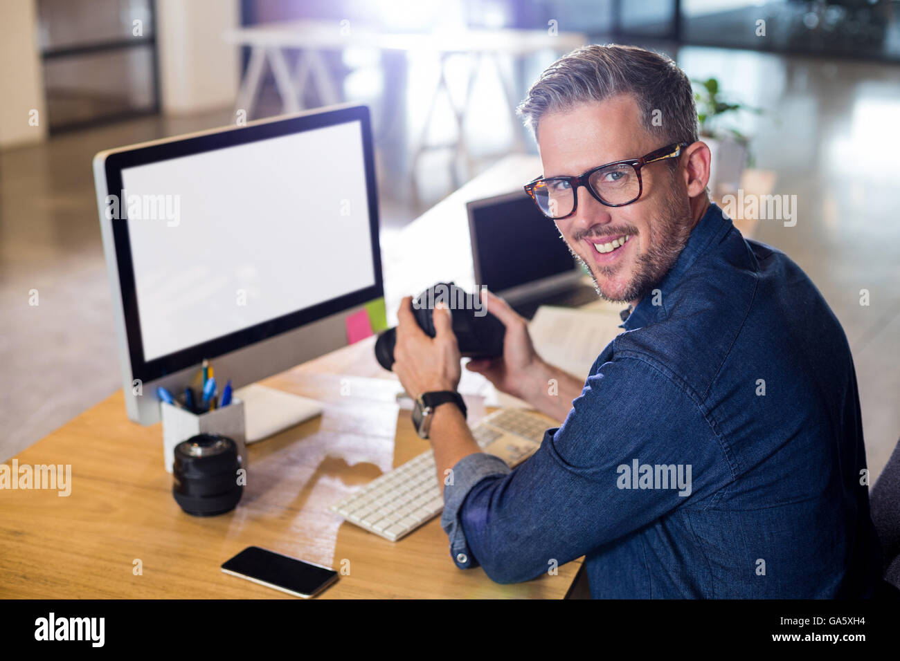 Portrait of smiling man holding camera Banque D'Images