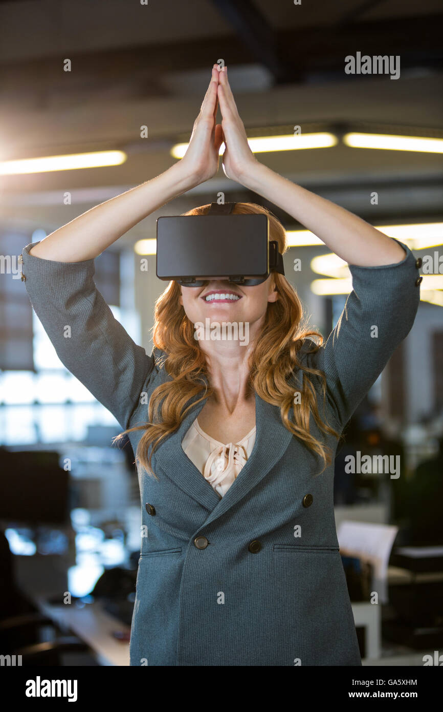 Businesswoman les mains jointes à l'aide d'un simulateur de réalité virtuelle Banque D'Images