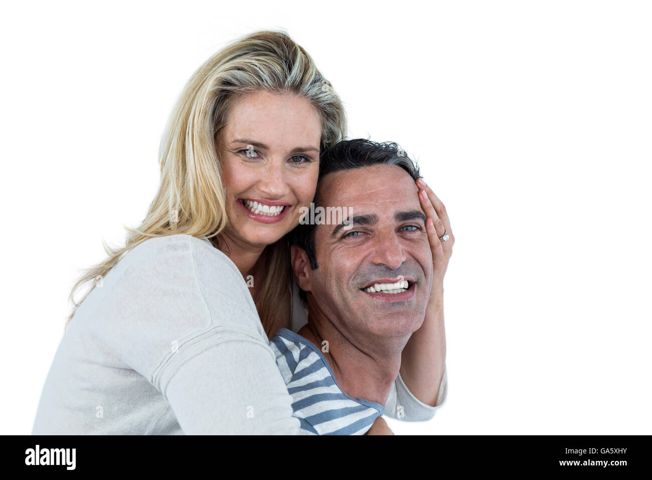 Smiling man carrying woman piggyback Banque D'Images