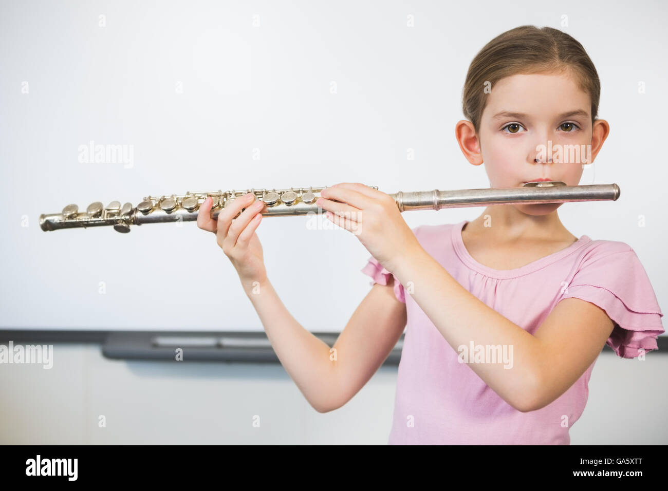 Portrait de lycéenne jouer flûte en classe Banque D'Images