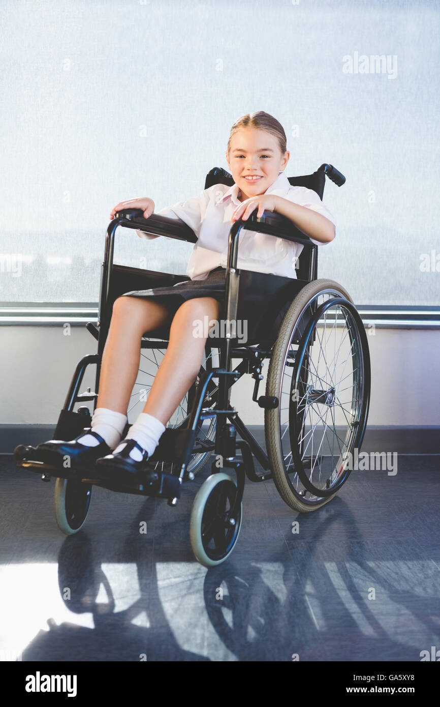Portrait de schoolkid assis sur fauteuil roulant Banque D'Images