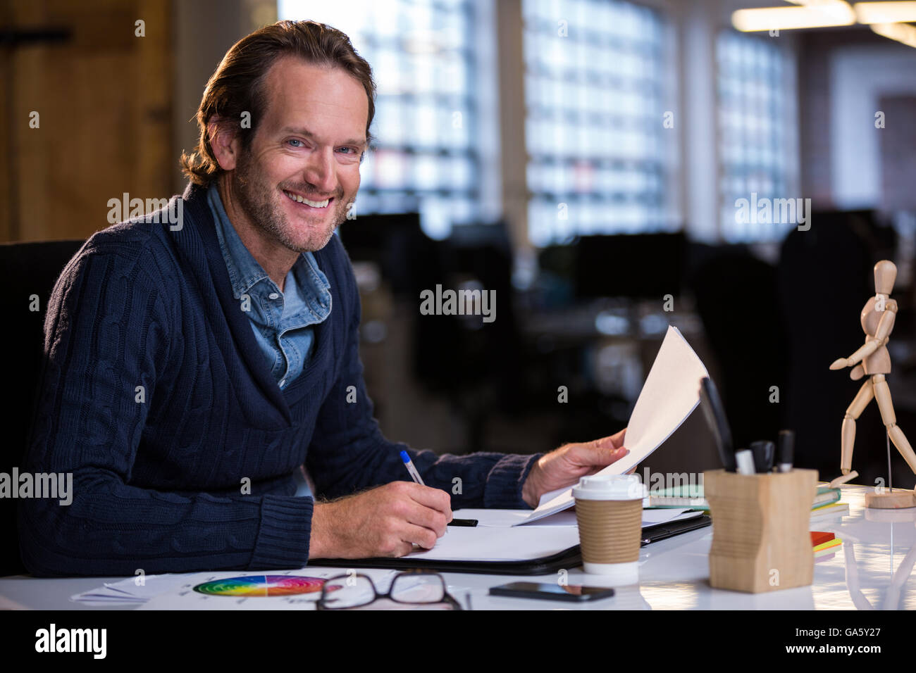 Businessman smiling while working at desk Banque D'Images