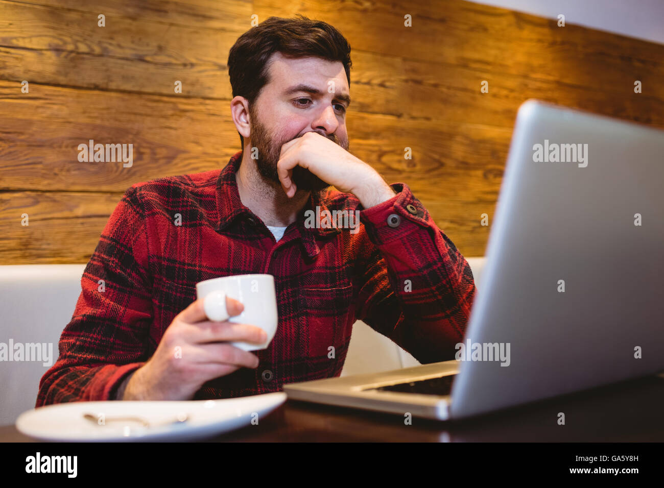 Man using laptop at table in restaurant Banque D'Images