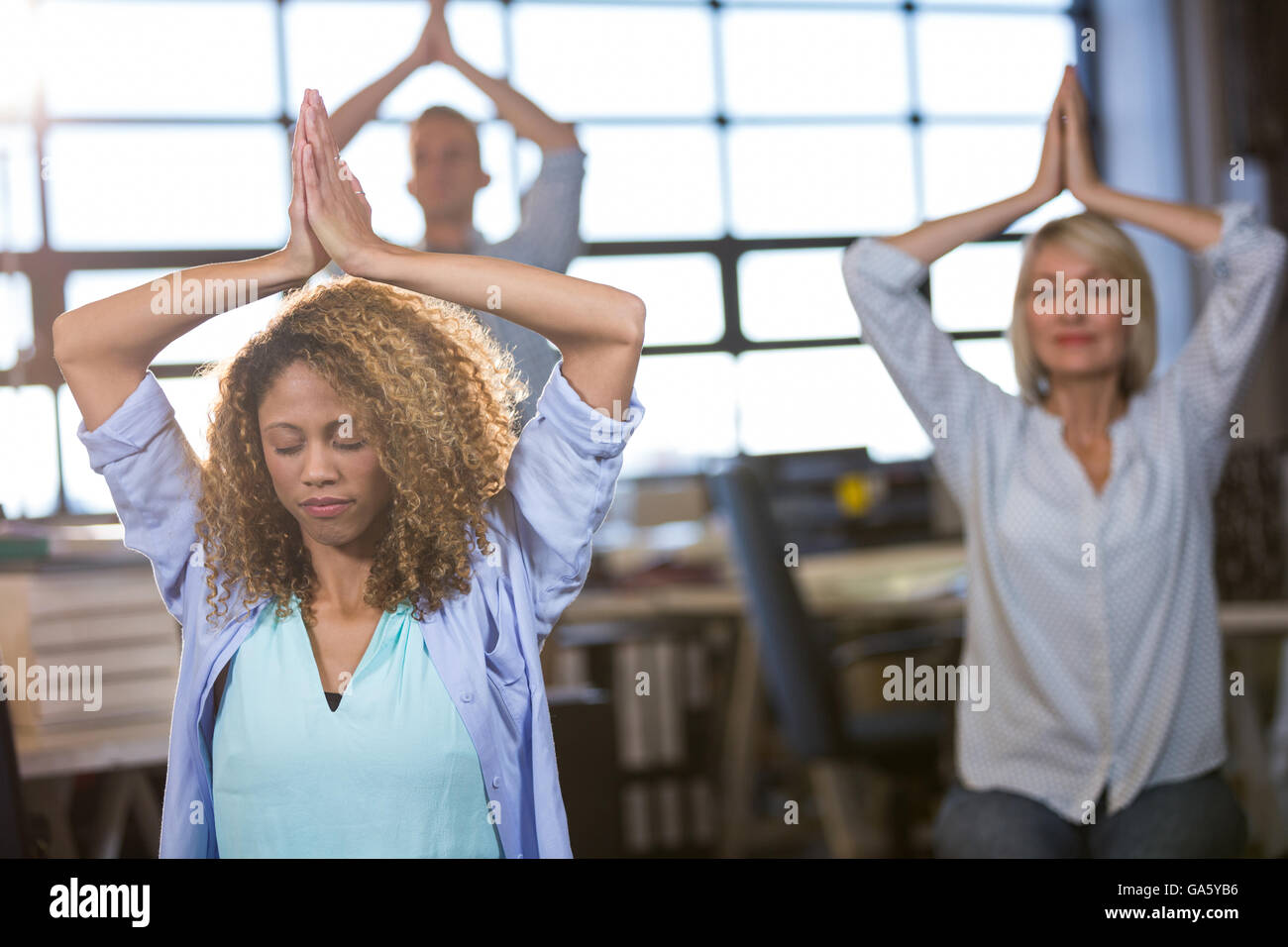 Creative business people practicing yoga Banque D'Images