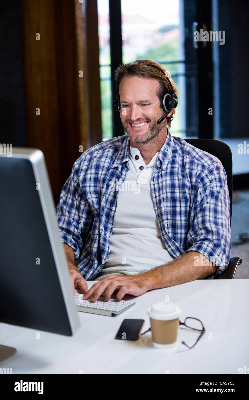 Creative Smiling businessman working on computer Banque D'Images