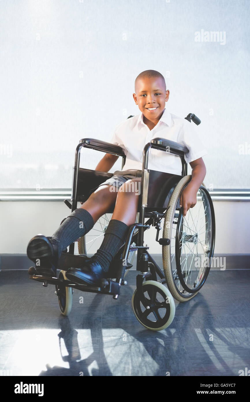 Portrait de schoolkid assis sur fauteuil roulant Banque D'Images