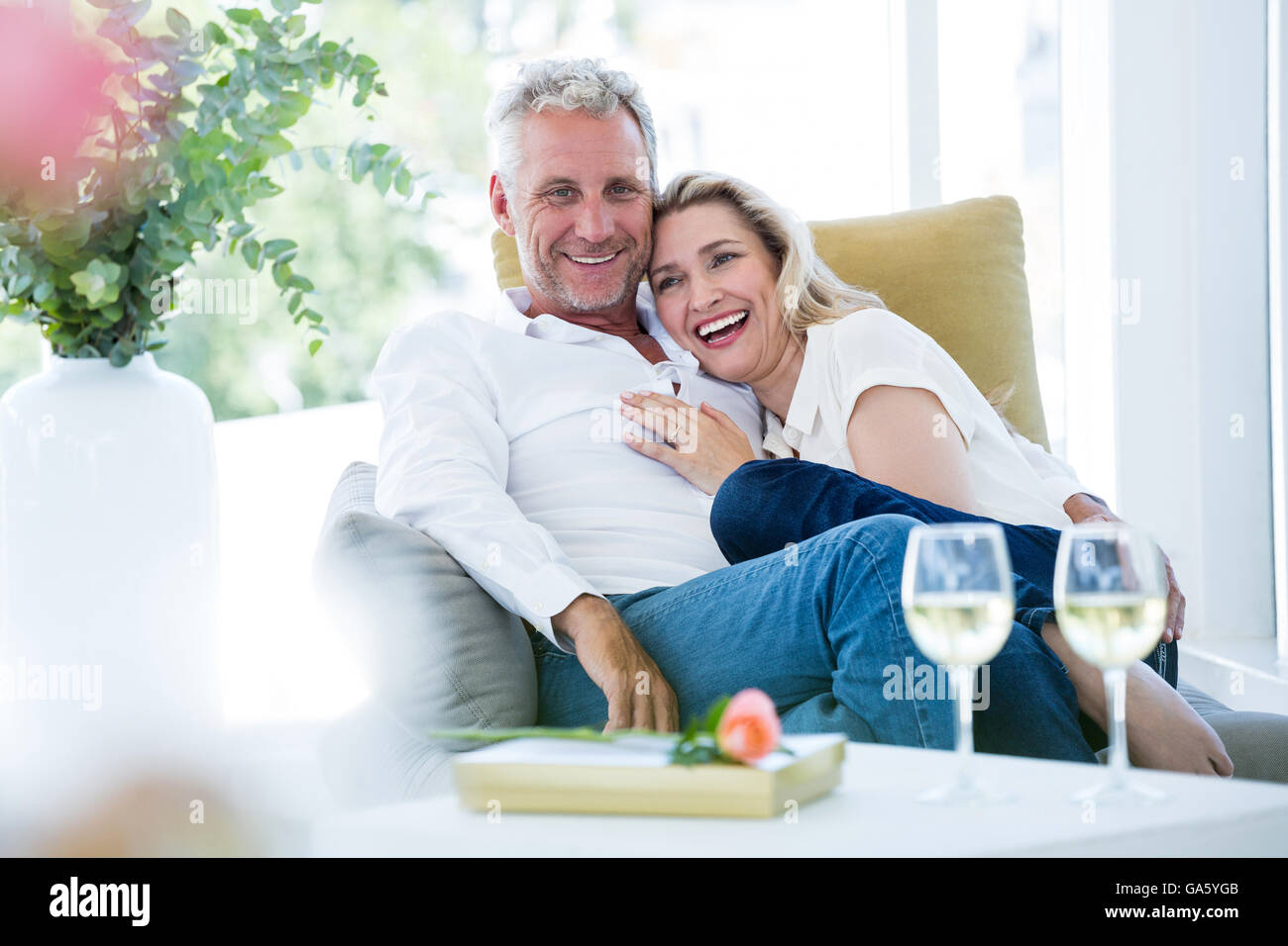 Happy young couple sitting on armchair Banque D'Images
