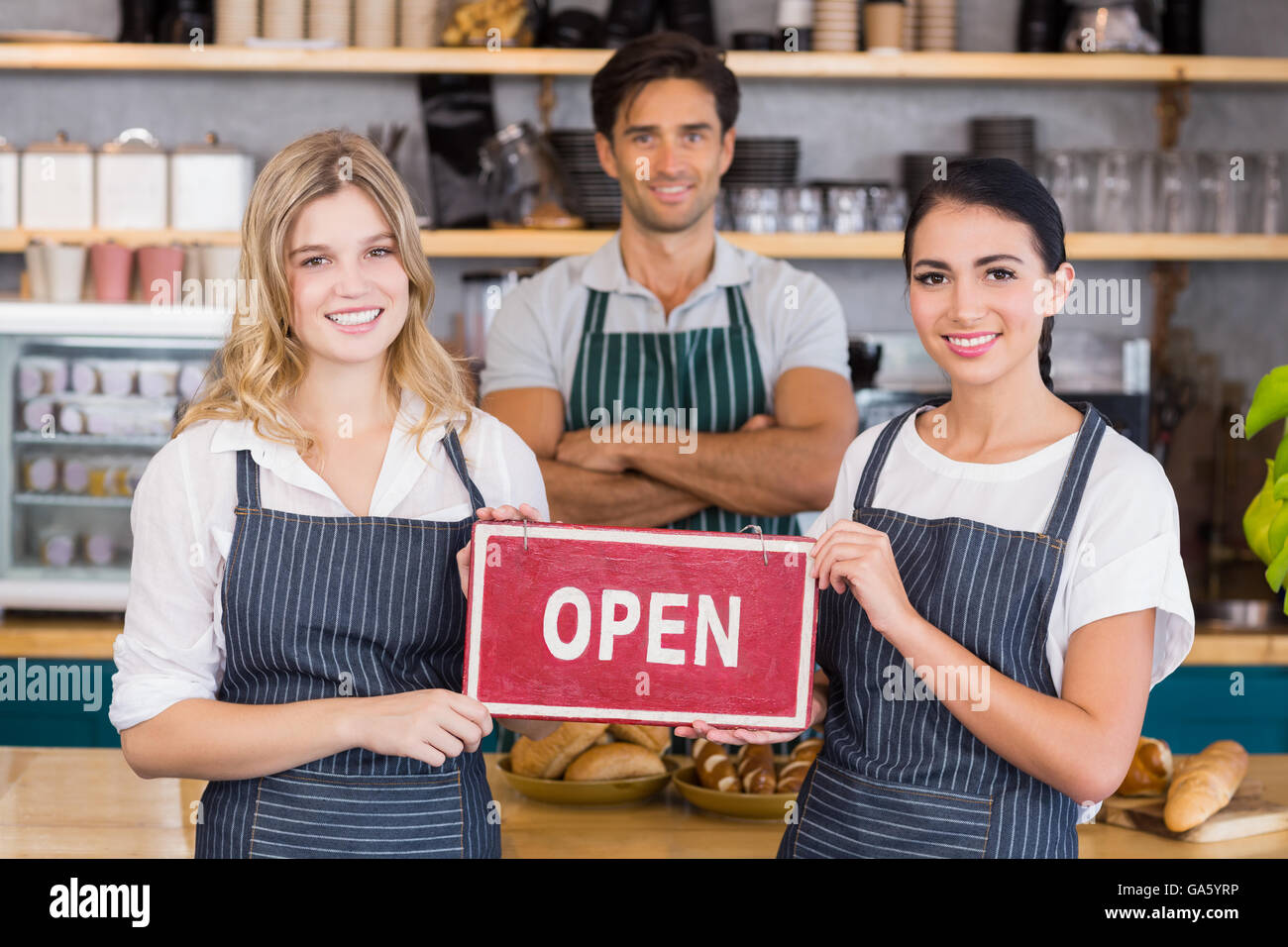 Smiling collègues montrant pancarte avec open sign Banque D'Images