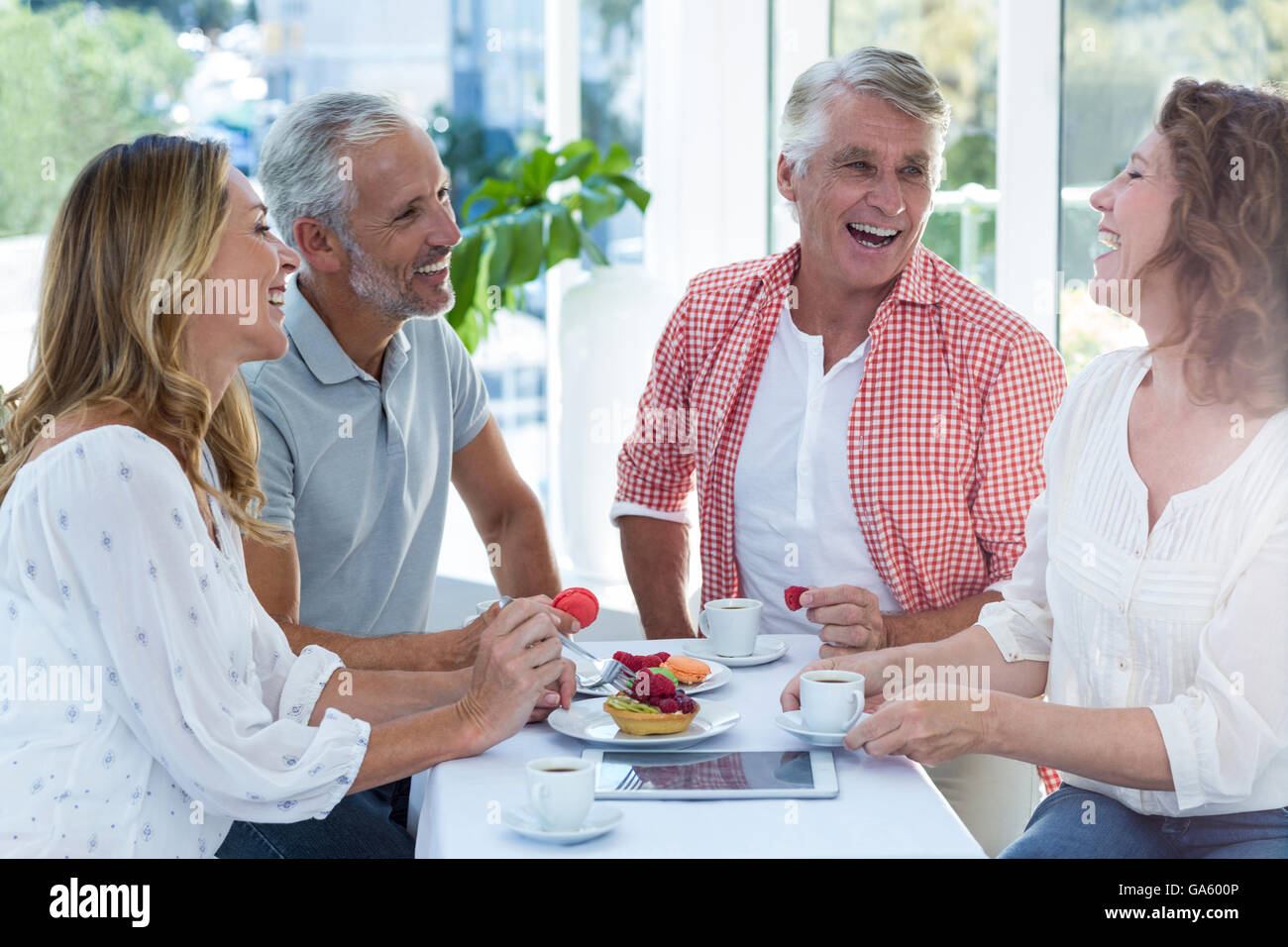 Les couples d'âge mûr ayant la cuisine du restaurant Banque D'Images