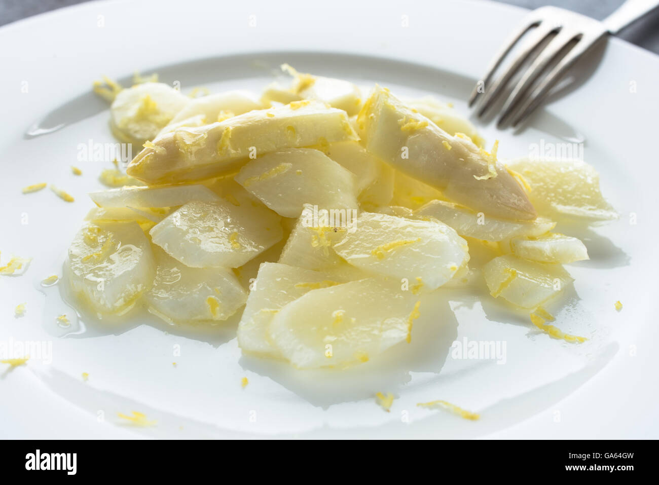 Salade d'asperges blanches brutes avec les zestes de citron sur une plaque Banque D'Images