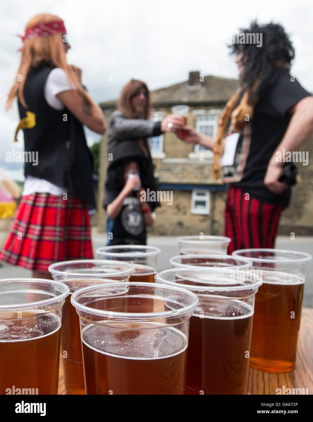 Concurrents prend part à la ferme de la course de la paille dans le Yorkshire, qui consiste à courir en robe de soirée, tout en portant une botte de paille et se rendant sur chacune des pubs locaux dans le village pour récolter des fonds pour des œuvres de bienfaisance. Banque D'Images
