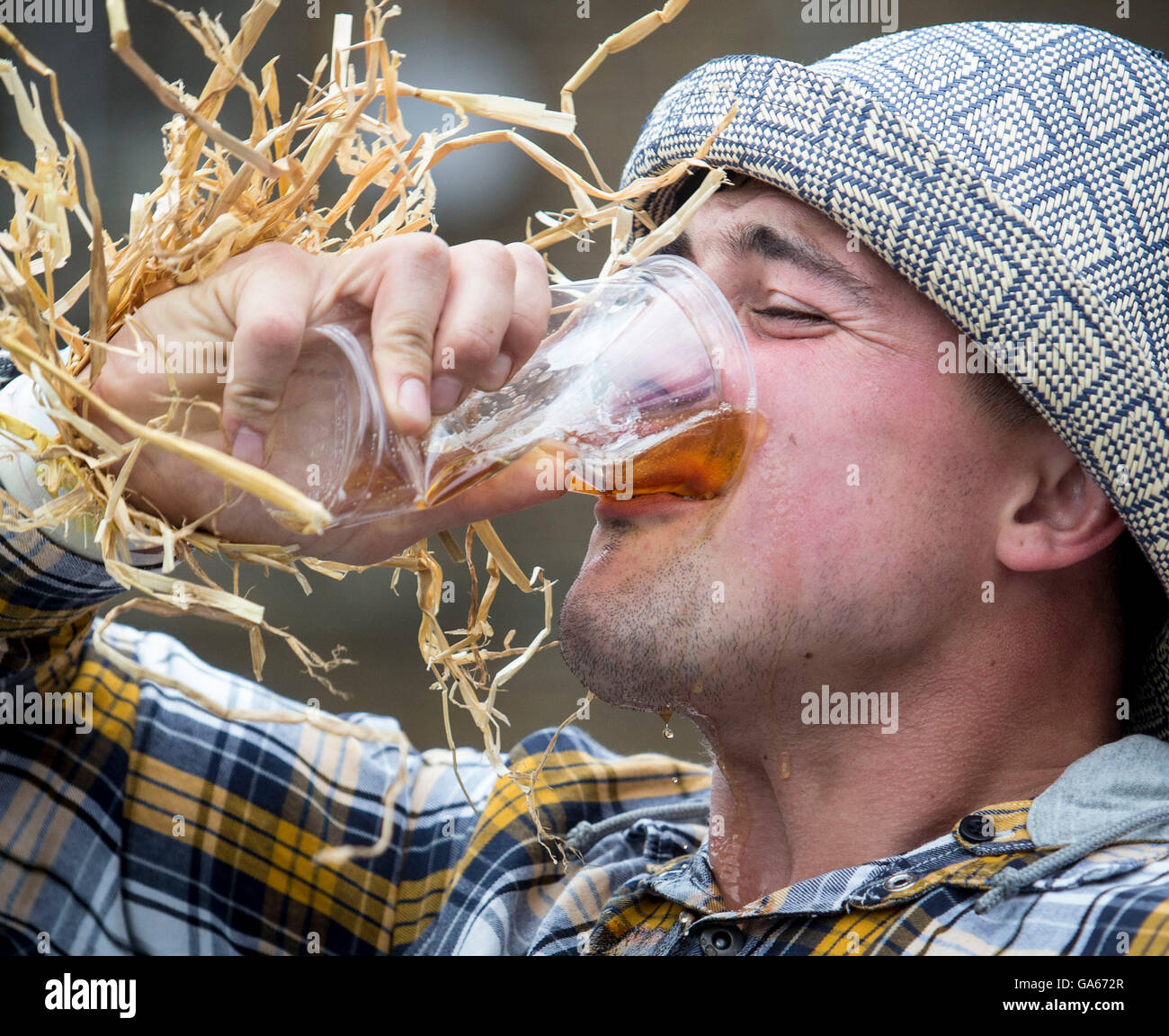 Un concurrent prend part à la ferme de la course de la paille dans le Yorkshire, qui consiste à courir en robe de soirée, tout en portant une botte de paille et se rendant sur chacune des pubs locaux dans le village pour récolter des fonds pour des œuvres de bienfaisance. Banque D'Images