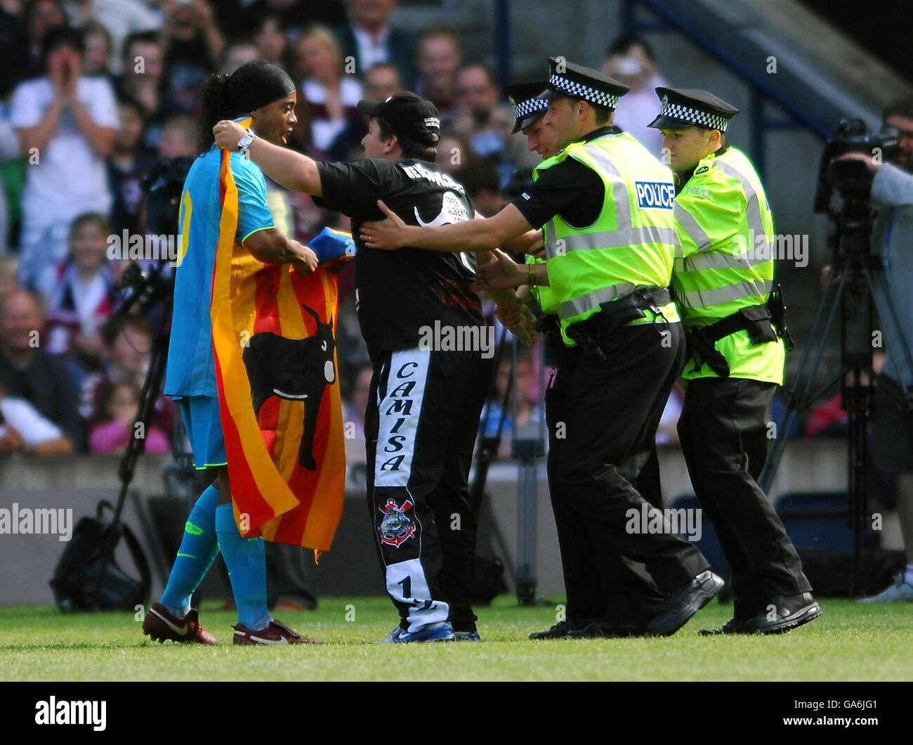 Le Ronaldinho de Barcelone reçoit un drapeau d'un manifestant qui a couru sur le terrain pendant le match amical contre les coeurs au stade Murrayfield, à Édimbourg. Banque D'Images